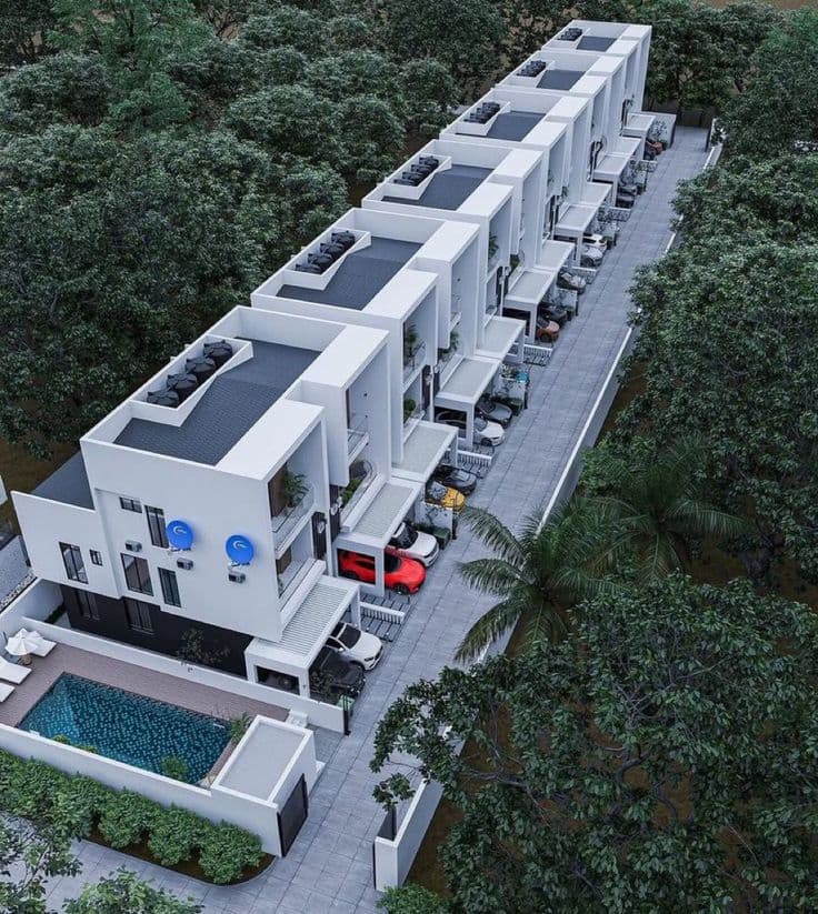 Aerial view of a terrace of white contemporary townhouses with rooftop terraces, a swimming pool and a palm-lined driveway